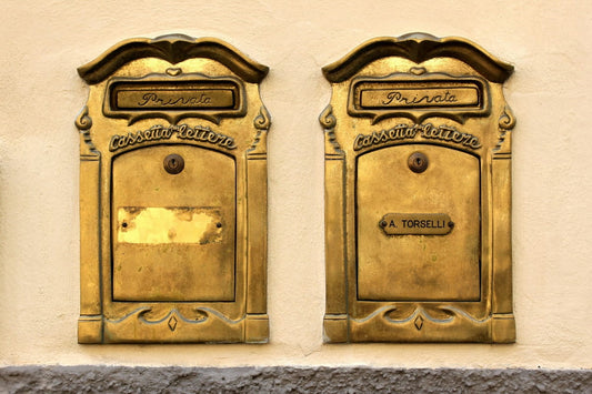 Two brass letterboxes on the wall 